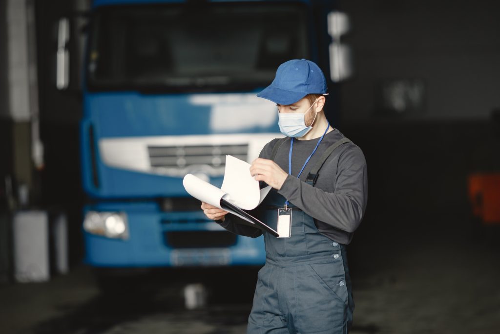 man in overalls checking truck documentation indoo 2026 01 07 05 49 23 utc
